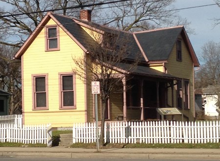 A two-story house with a white picket fence
