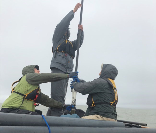 scientists on a boat taking sediment cores
