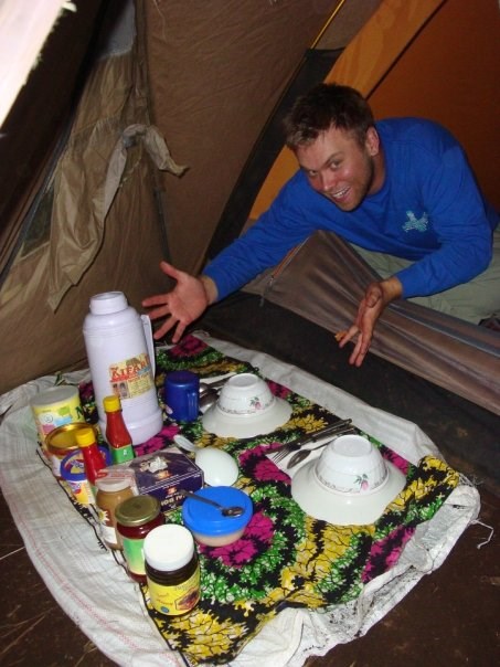 Nathan King camping in a tent with a full supply of food