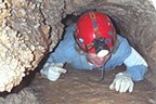 person crawling through cave
