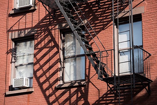 Brick building with windows and fire escape at Stonewall