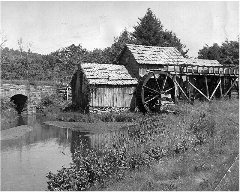 Reflecting pond and crafted stone bridge beside the wooden Mabry Mill