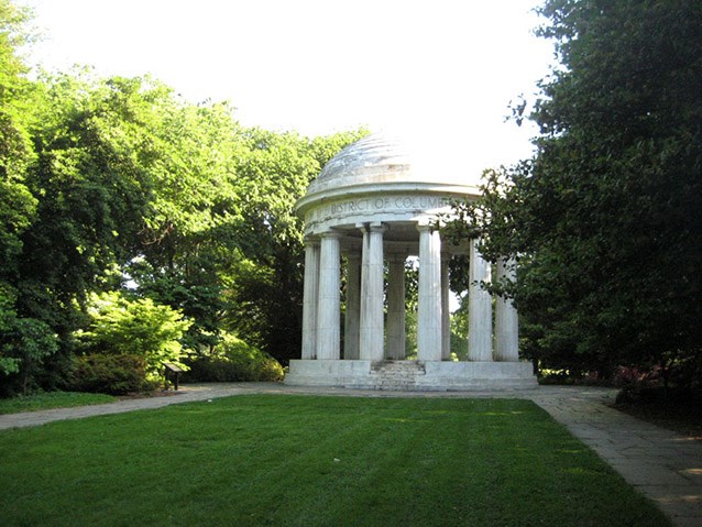 An area of bright lawn leads towards a rotunda encircled by white marble columns