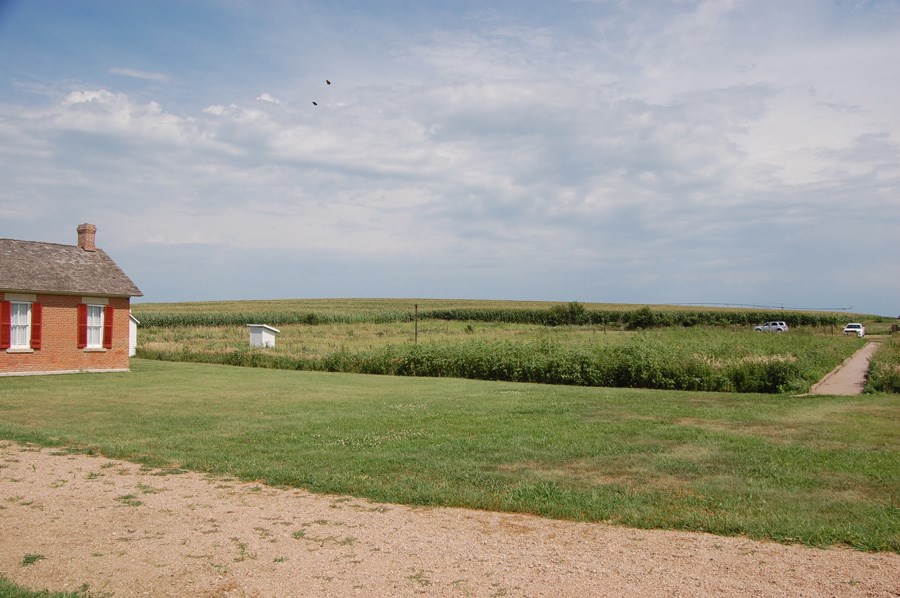 Open grassy area beside the one-room brick Freeman School