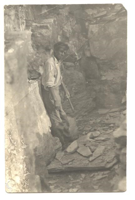 Joe Taylor leaning back against the wall of a quarry looking at the camera