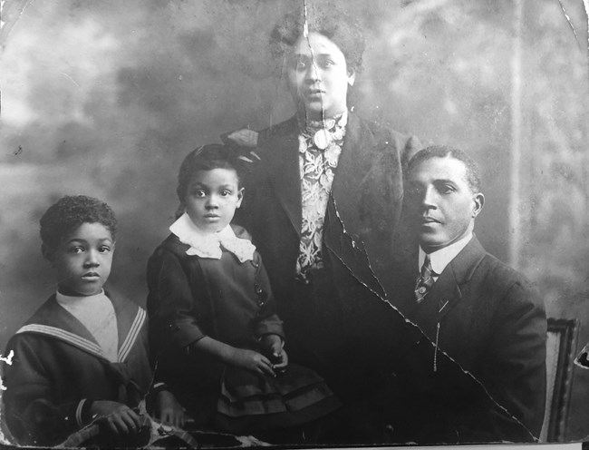 The Young family - a man, woman, and two children - pose for a photograph, 1911.