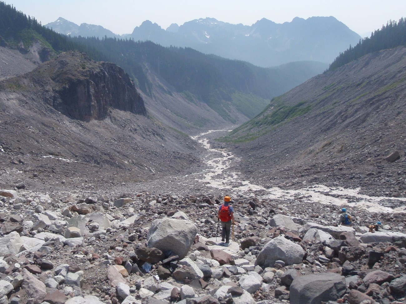 person hiking through large u-shaped valley