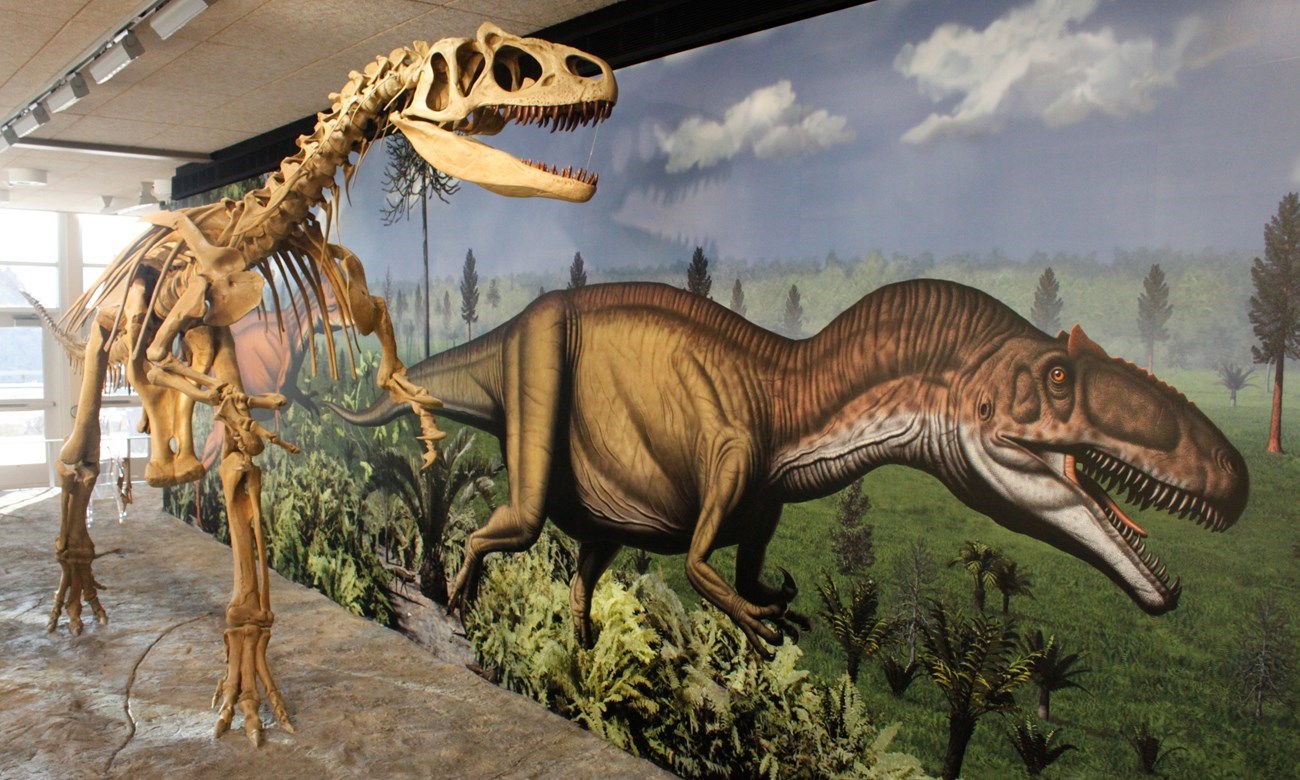 Photo of a dinosaur skeleton and a dinosaur mural