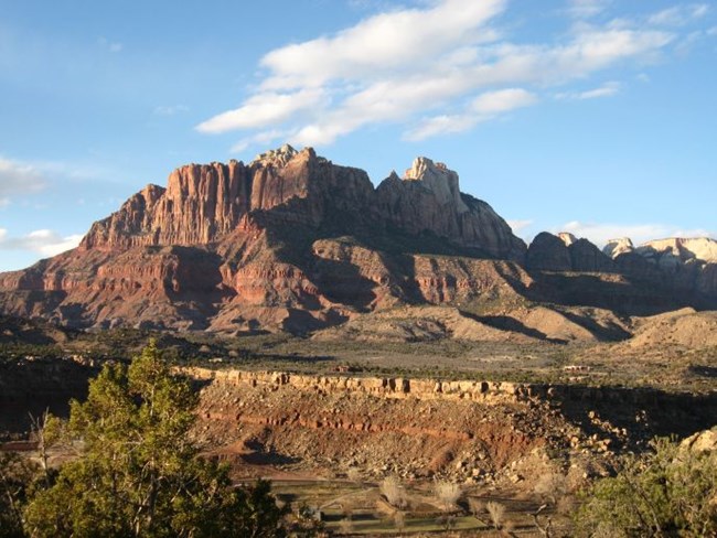 Photo of layered rock bluff and distant mountain