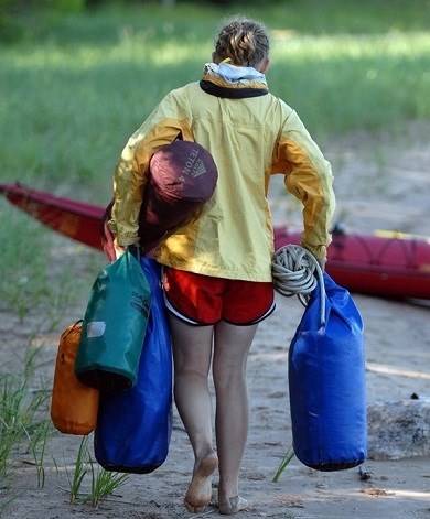 Girls carrying gear and packing up after kayaking