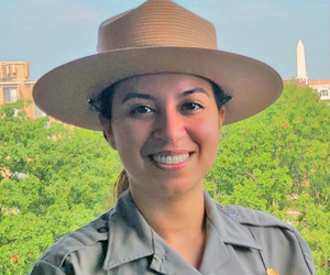 picture of woman posing in National Park Service Uniform with trees in background