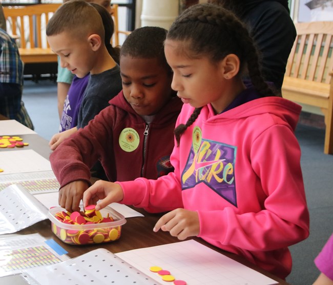 Two children work on arts and crafts at Kansas Day at the Museum.