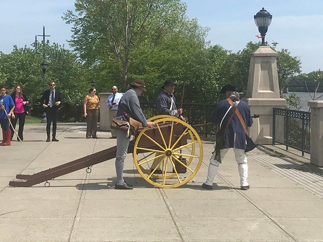 Historical reenactors from Schuyler’s 2nd Regiment prepare to fire a cannon