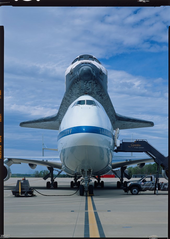 Front view of the Orbiter Discovery and the Shuttle Carrier Aircraft on the tarmac at Dulles International Airport