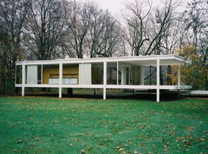 Farnsworth House, with green lawn in foreground and bare trees in the background