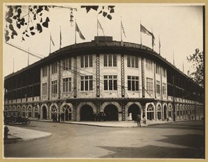 Arched entryway to Forbes Field, with flags flying above the field.