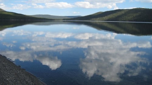 Clouds reflect off of Shoshone lake in Yellowstone National Park.