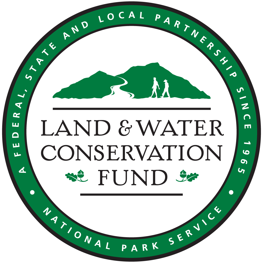 Green circle border with the words “A Federal, State and Local Partnership Since 1965” and “National Park Service.” Inside, green mountains with two hikers, and the text “Land & Water Conservation Fund” with oak leaf and acorn icons.