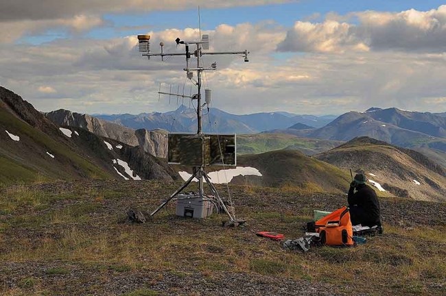 A researcher sets up a climate station high in the Brooks Range.