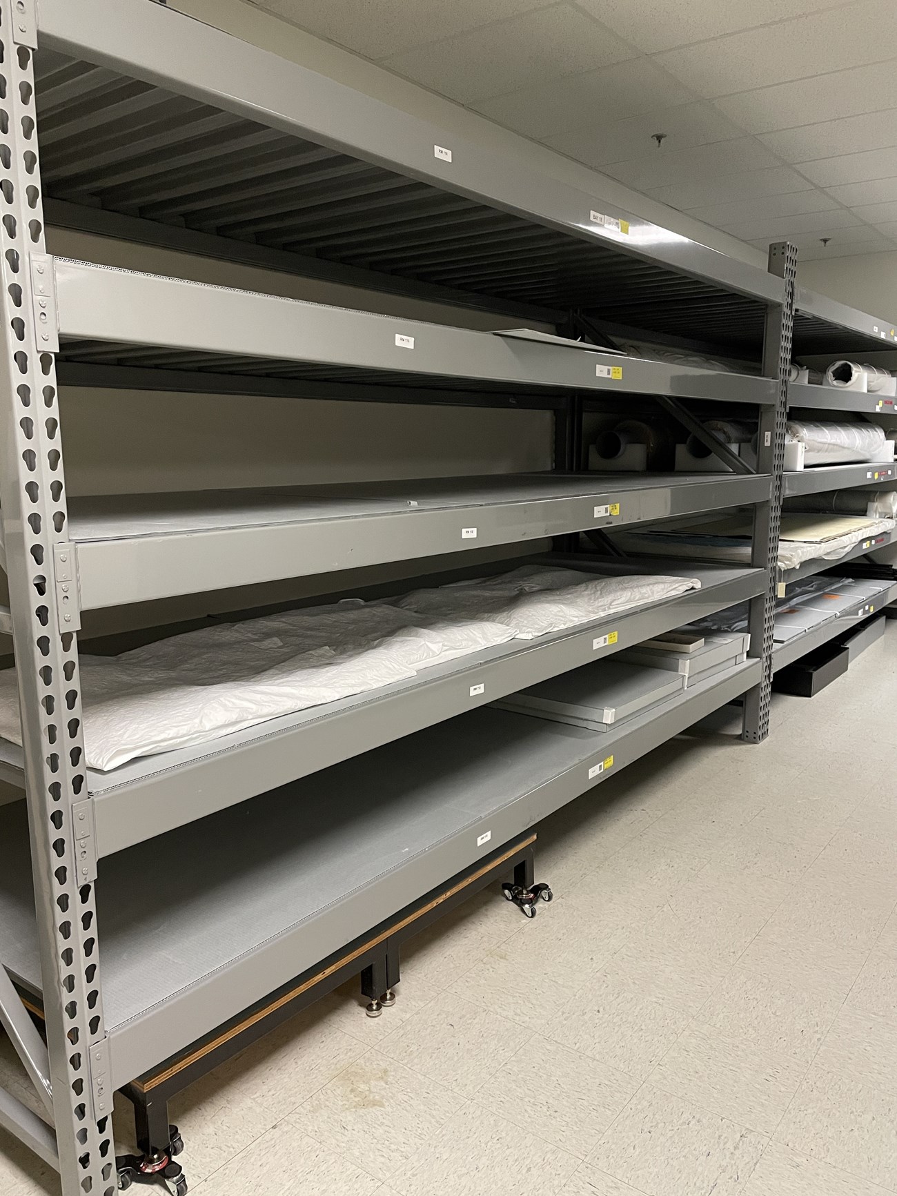 Gray metal shelves holding heavy, oversized objects.