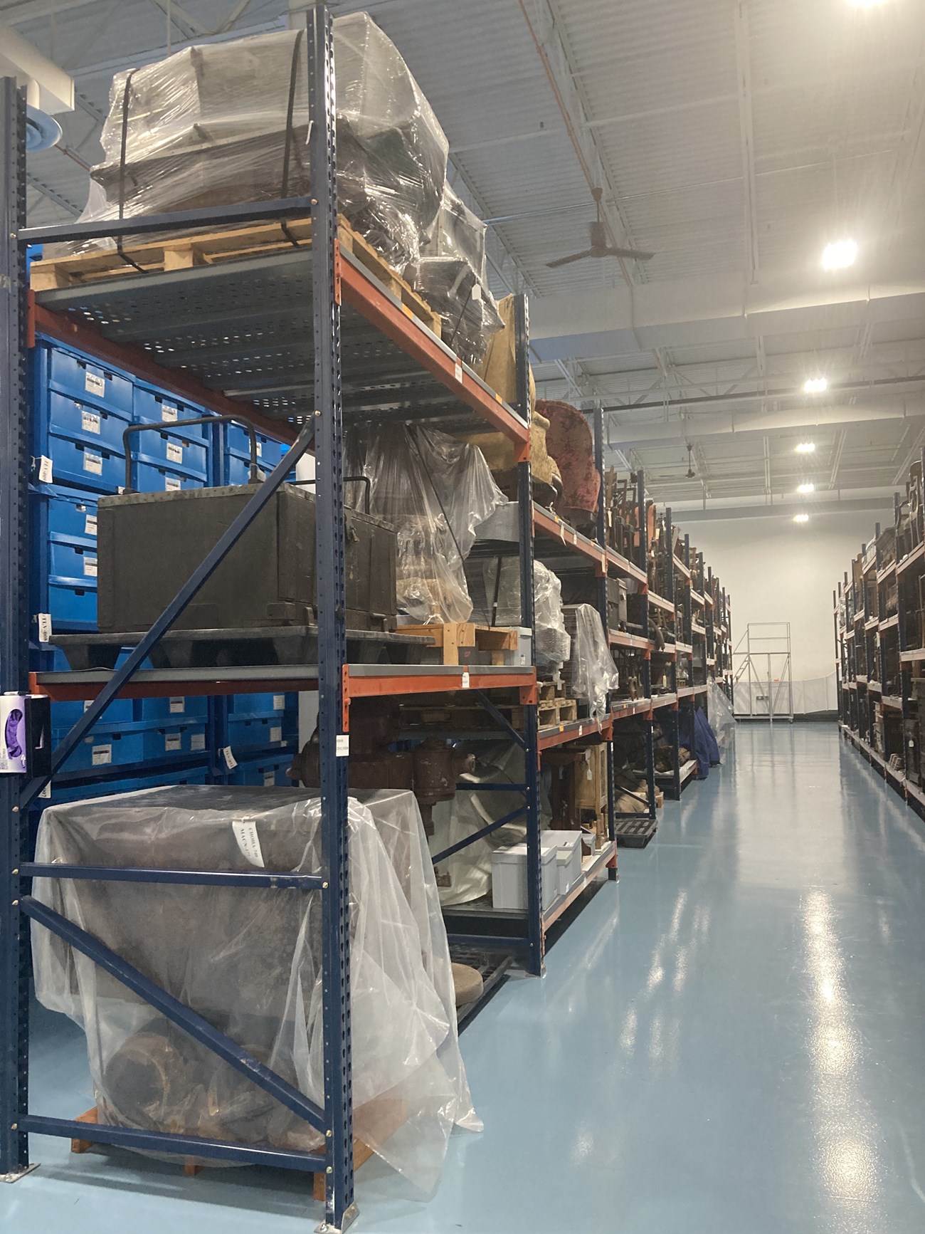 Metal racks holding large objects stored on pallets.