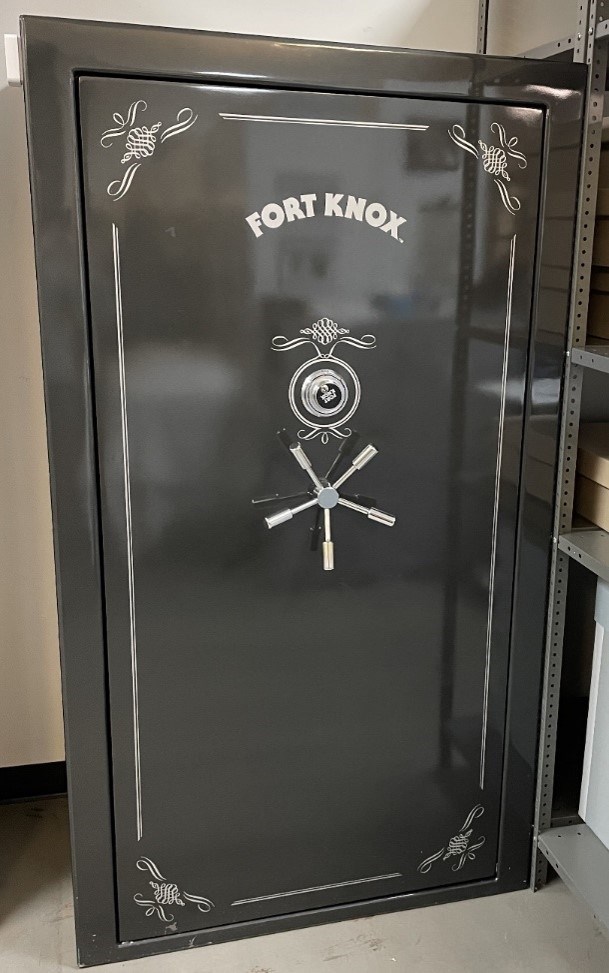 A gray gun safe with a combination lock on the door.