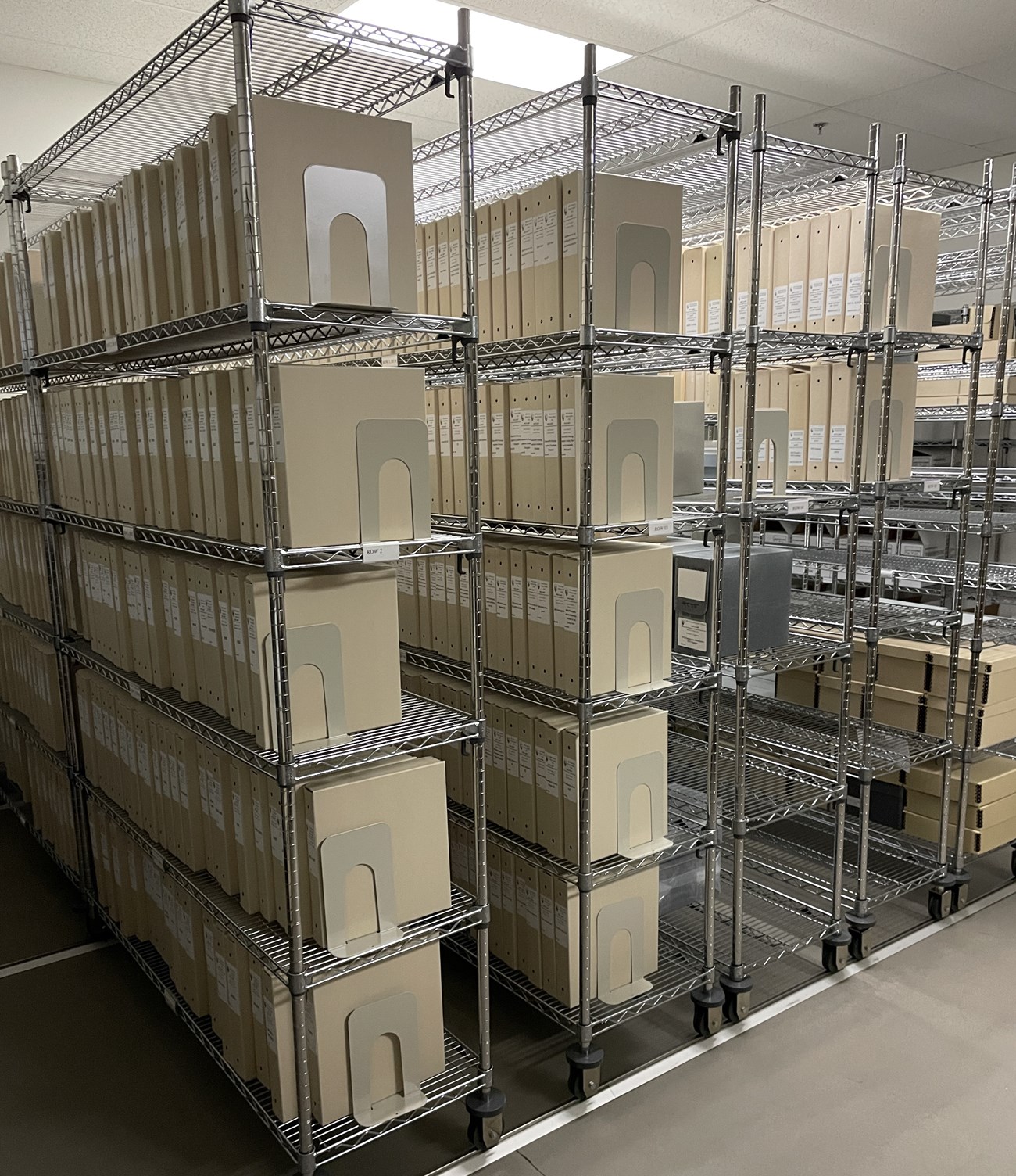 Wire racks that are mounted on a compact system track holding archives boxes