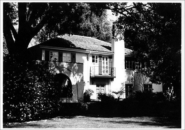 Image of white house, trees, lawn.