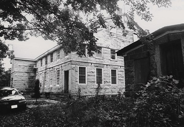 Image of stone building at top of grassy hill.