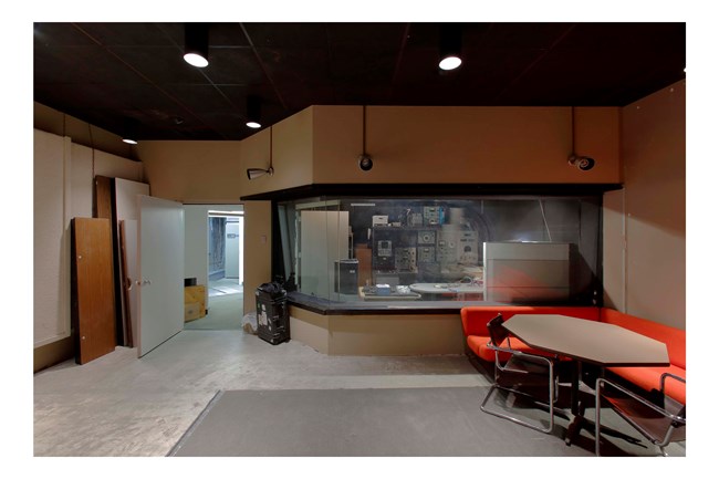 Interior of recording studio showing equipment, table, and seating area