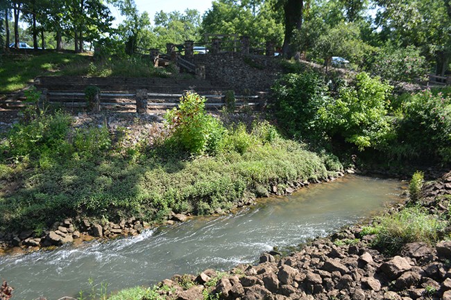 Image of water, plants, and stone structures.