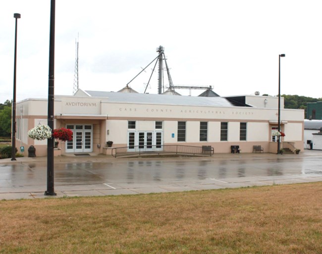 Image of white building surrounded by asphalt pavement.