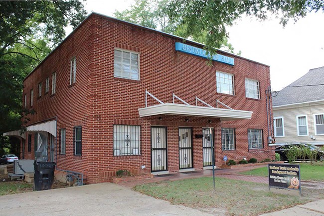 Two-story brick building with blue sign on brick.