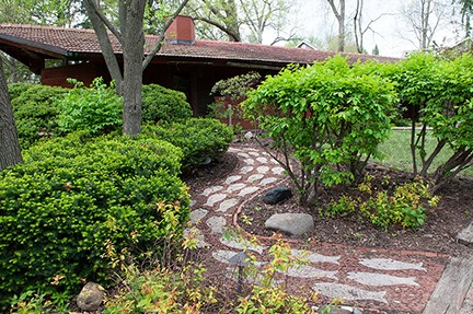 Image of house, walkway, and vegetation.