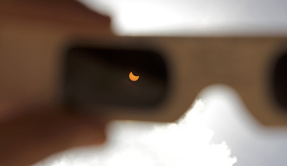 Eclipse in focus in the lens of eclipse glasses
