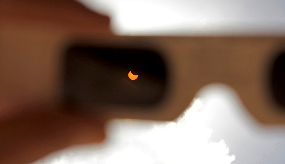 Eclipse in focus in the lens of eclipse glasses