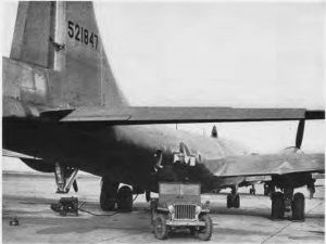 Black and white photo jeep park at tail of B-29. Tail Number reads 521847.