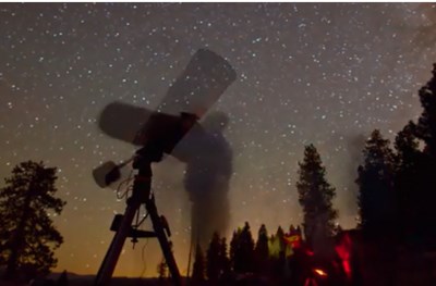 Night view of starry sky and people using a telescope