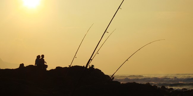 Visitor fishing from shore at Kalaupapa National Historical Park.
