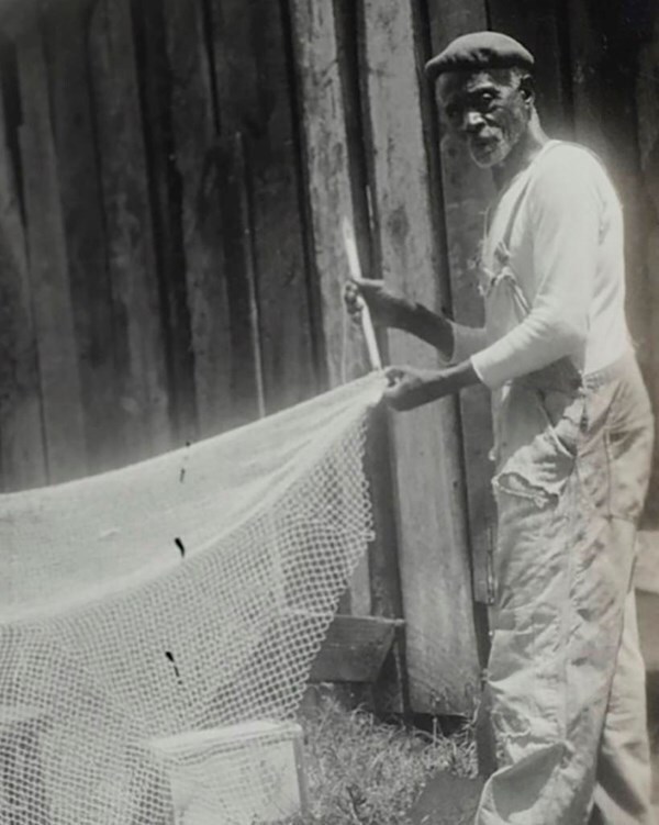 Sam Polite standing with a fishing net stretching the net out.