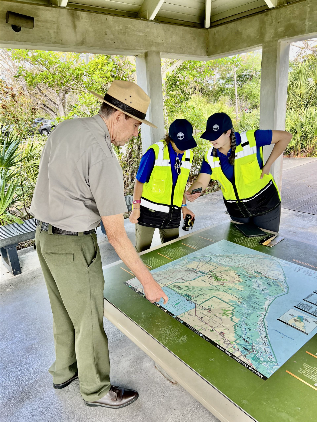 A ranger looks over a map with surveyors