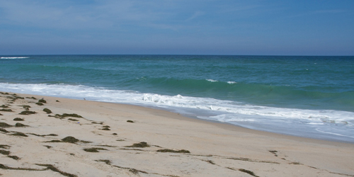 Ocean waves washing up on a sandy beach.