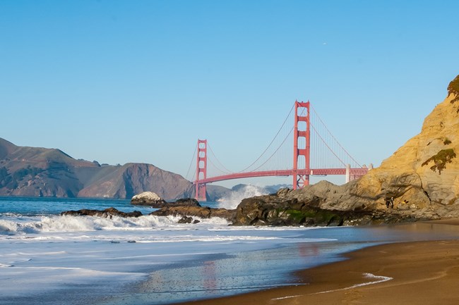 a sandy beach with the golden gate bridge in the background