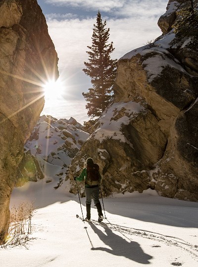 Woman skiing between snowy boulders on sunny day