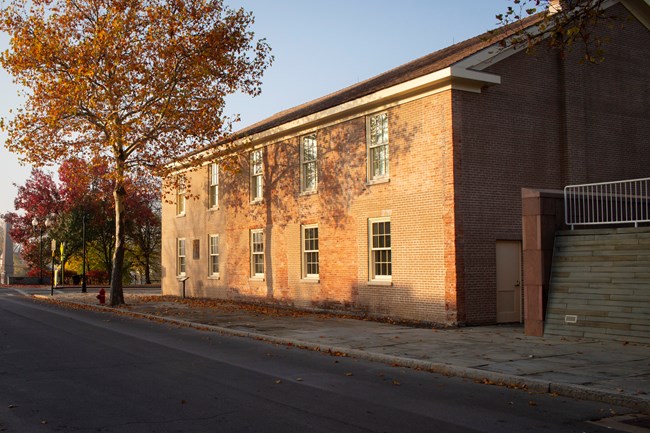 Large two-story red brick building lined with windows