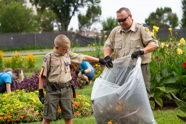 Scout Ranger and troop leader clean up park.