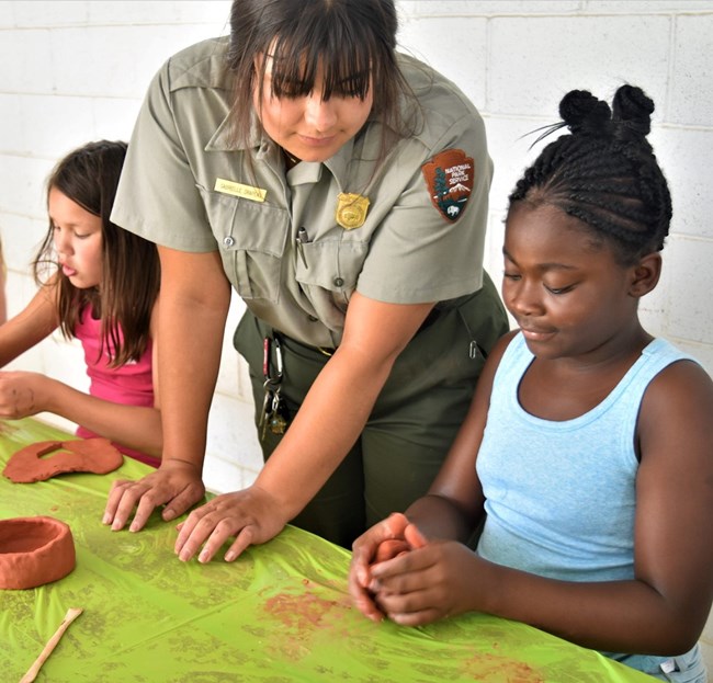 Ranger and Girl Scout making pottery