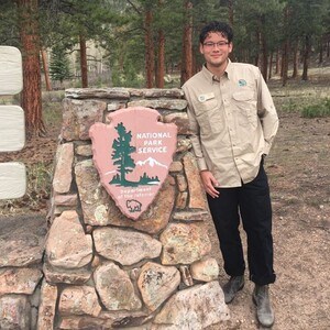 Intern next to National Park sign