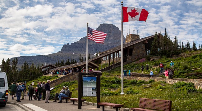 Flagpoles outside busy visitor center on hill