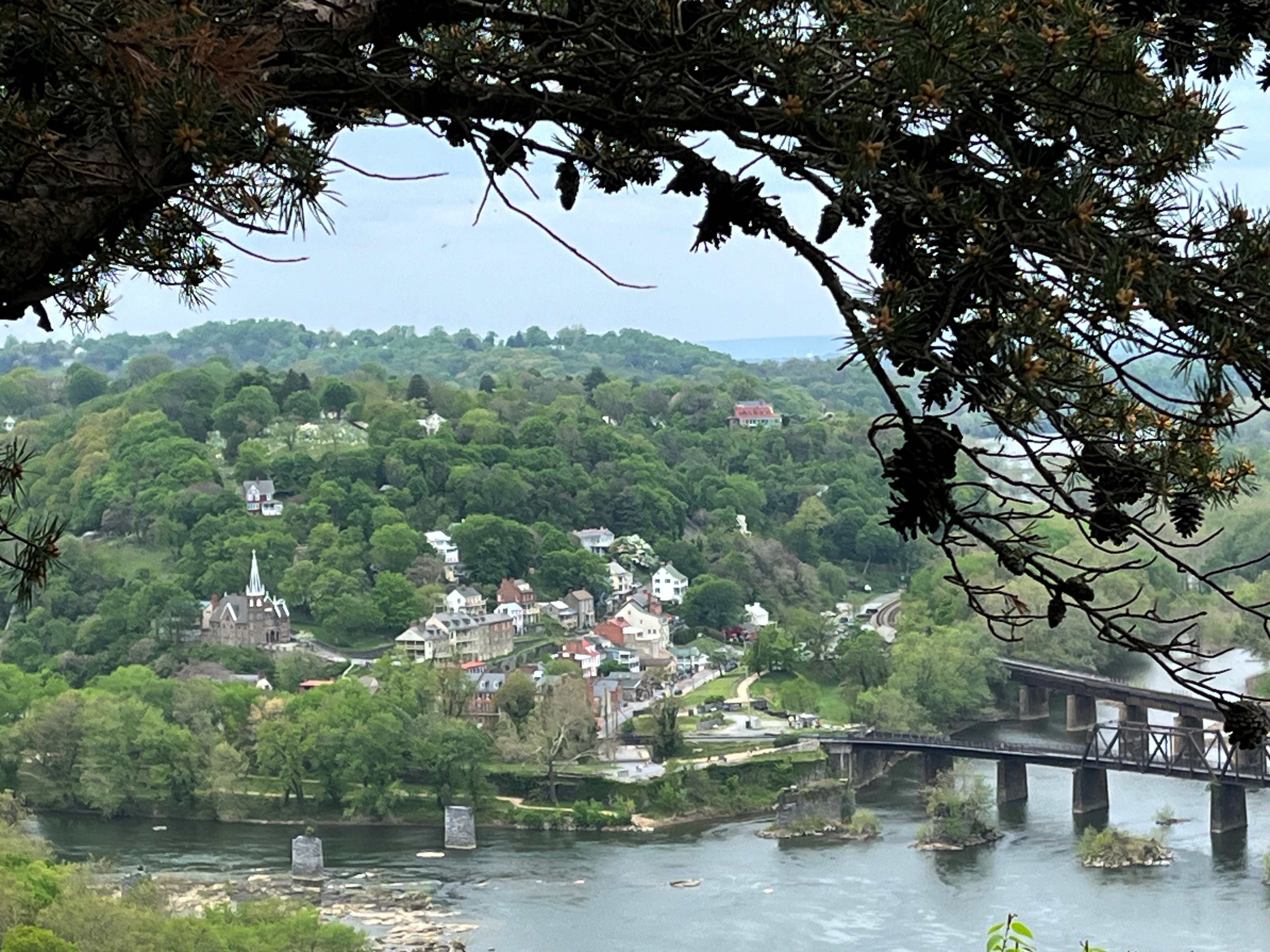 View of the meeting of two rivers with a small town and a bridge.